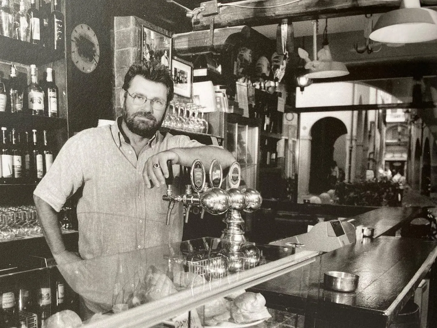 Foto storica in bianco e nero: il proprietario dietro il banco